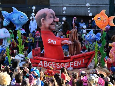 Karnevalsumzug mit einer Figur von Kanzler Scholz  